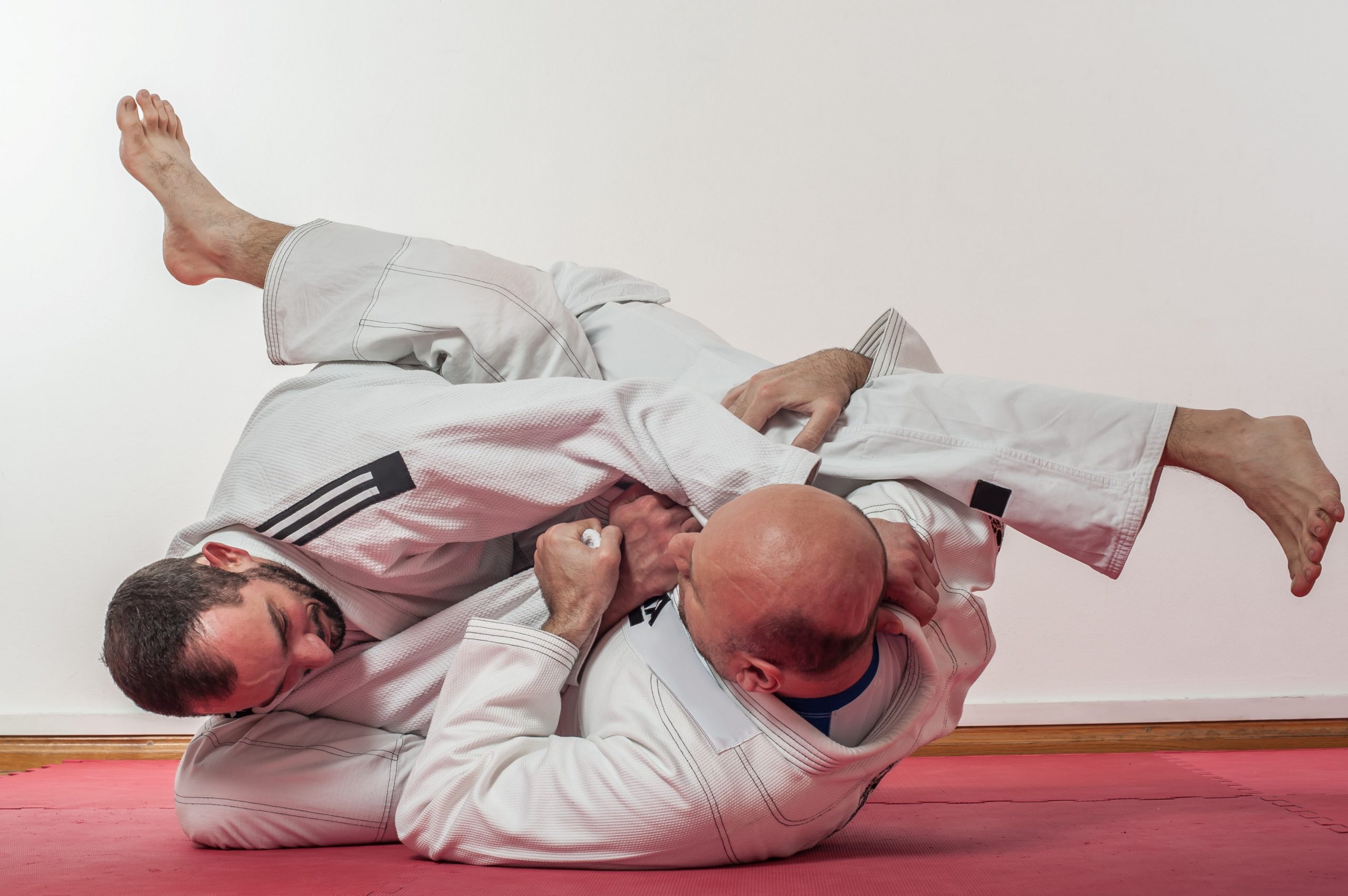 Two men doing a Brazilian jiu-jitsu training demonstration in traditional kimono