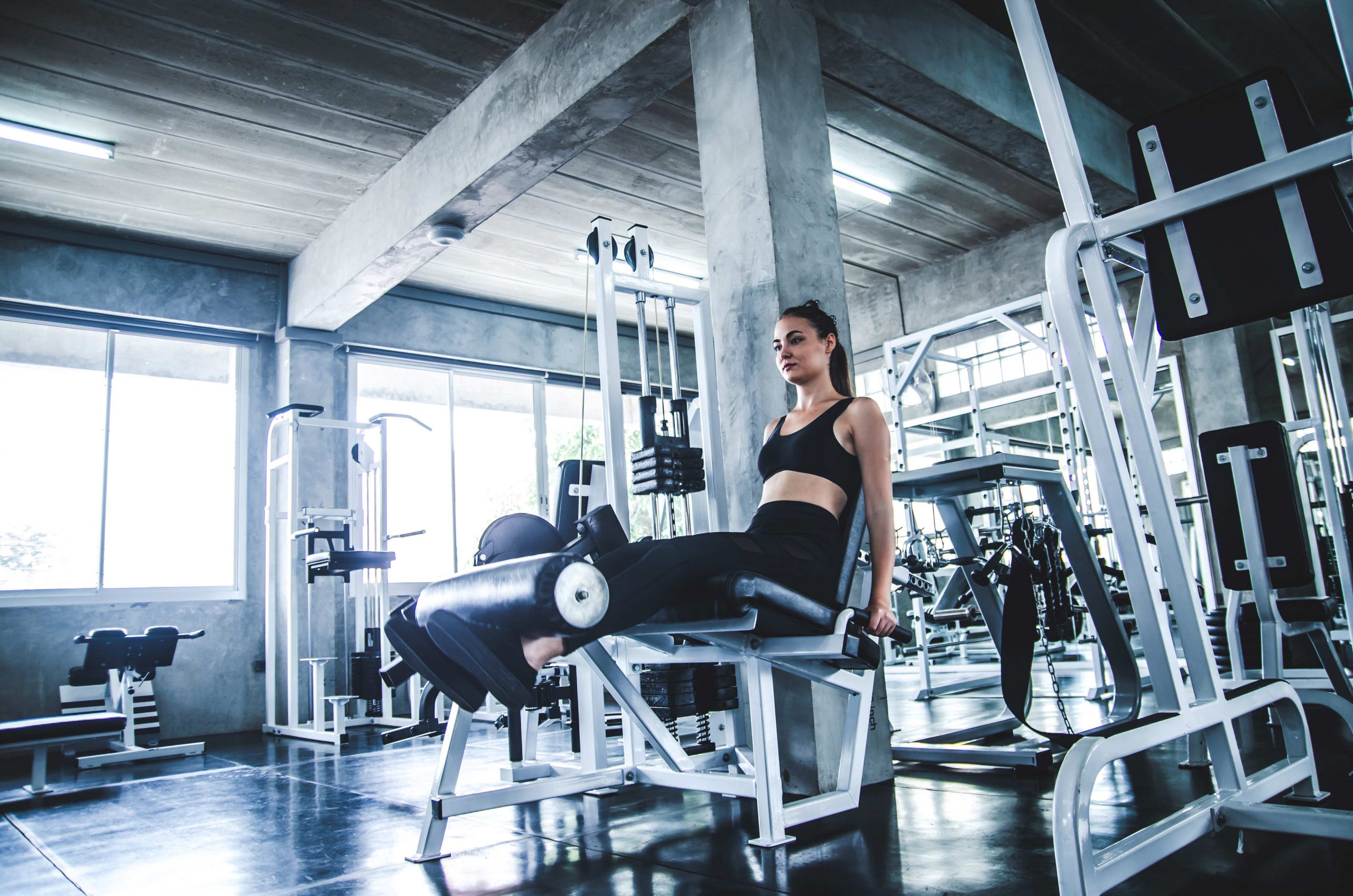 Woman working out in fitness gym on exercise machine