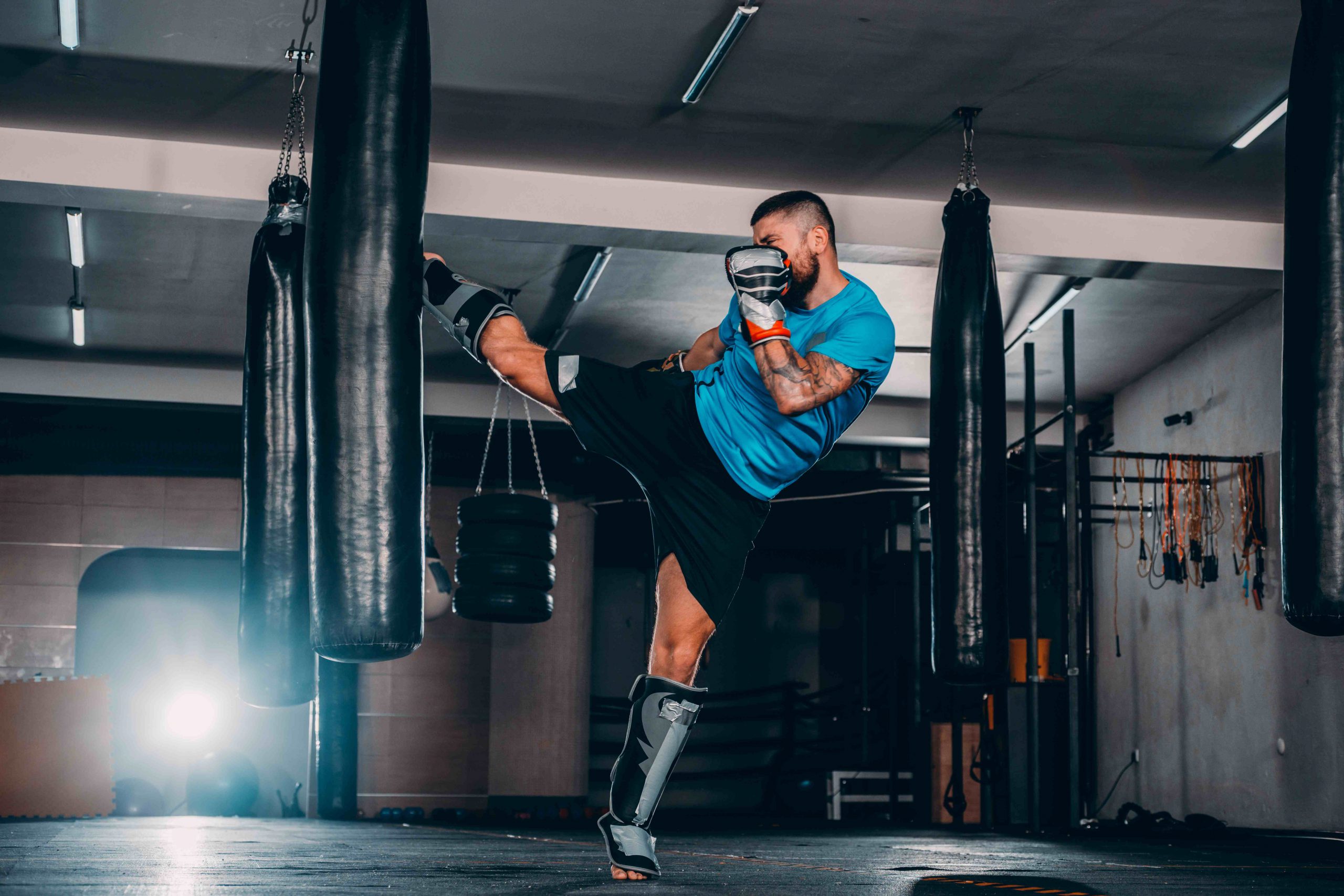 Man kicking punching bag during kickboxing workout